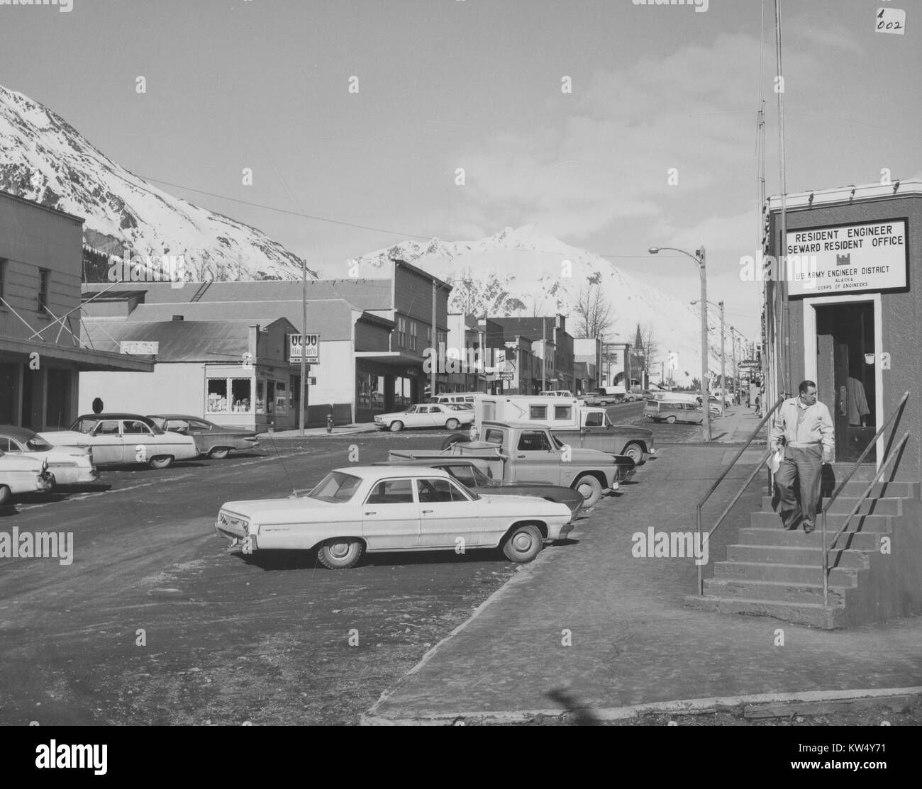 View down a fairly busy street with commercial buildings in Seward, Alaska, 1964. Stock Photo