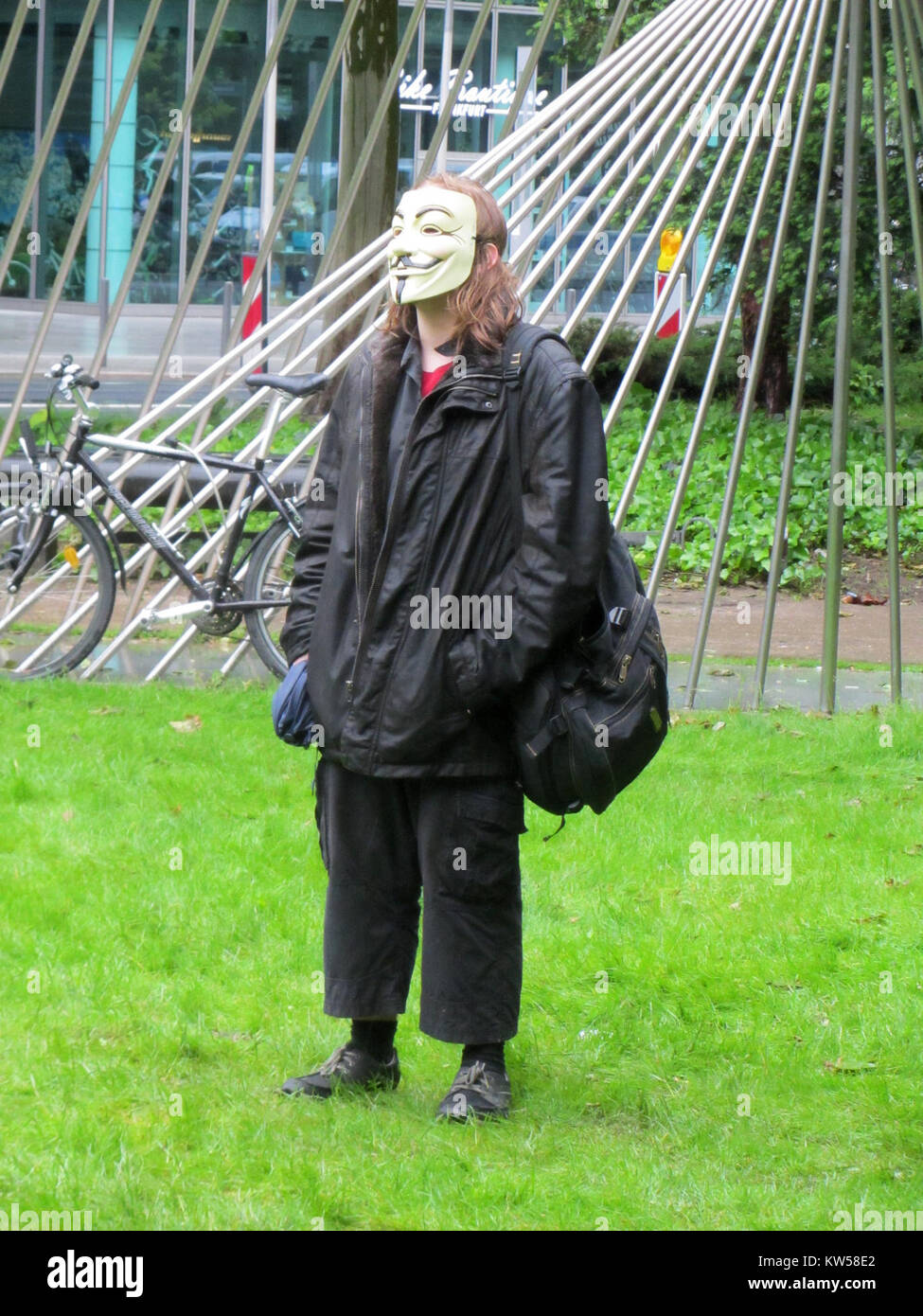 This image from the 2013 Blockupy protest in Frankfurt shows a demonstrator wearing a Guy Fawkes mask, a symbol of anti-authoritarian activism. The protest was organized against austerity measures, corporate influence, and the European Central Bank's policies. Stock Photo