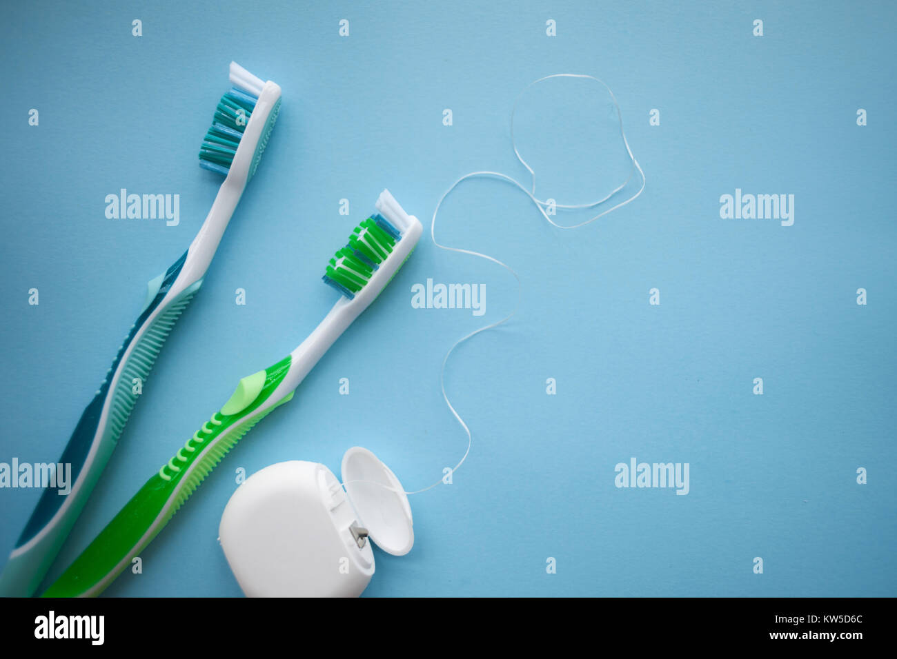 Two toothbrushes and dental floss on blue background, top view Stock ...