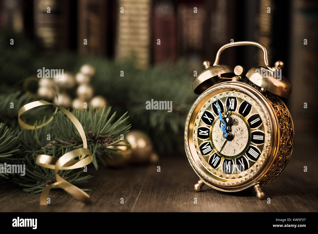 Vintage alarm clock in traditional study room showing five to midnight. Happy New Year! Stock Photo