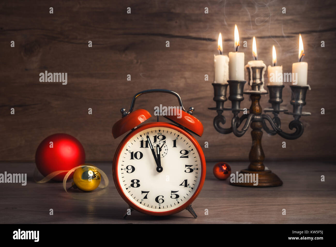 Vintage alarm clock showing five to twelve with Christmas baubles on wood. Happy New Year 2017! Stock Photo