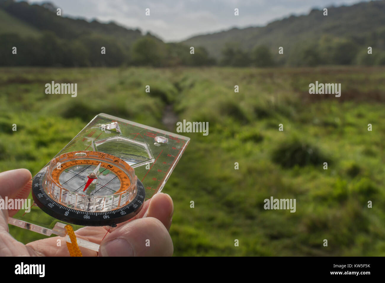 Orienteering compass in hand for business 'direction', navigation