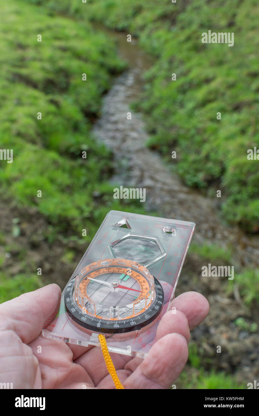 Orienteering compass in hand pointing East. For business 'direction