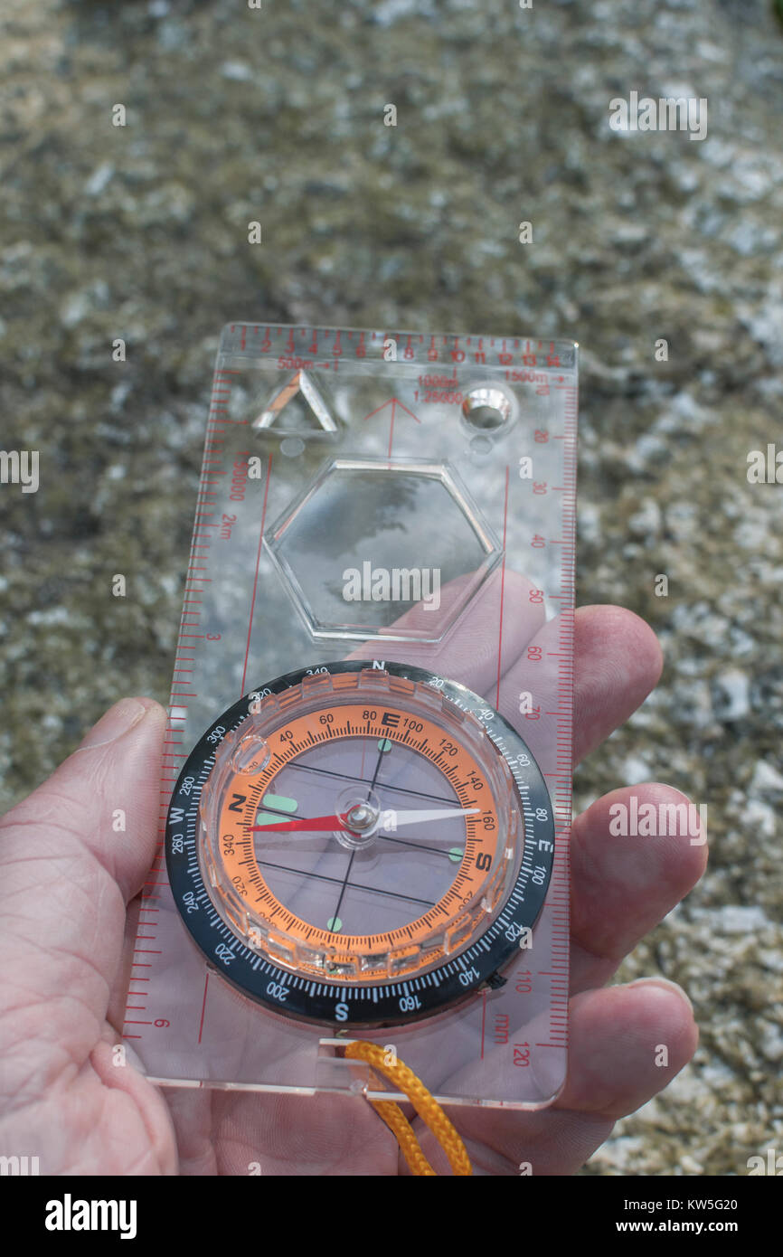 Orienteering compass in hand pointing north. For business 'direction