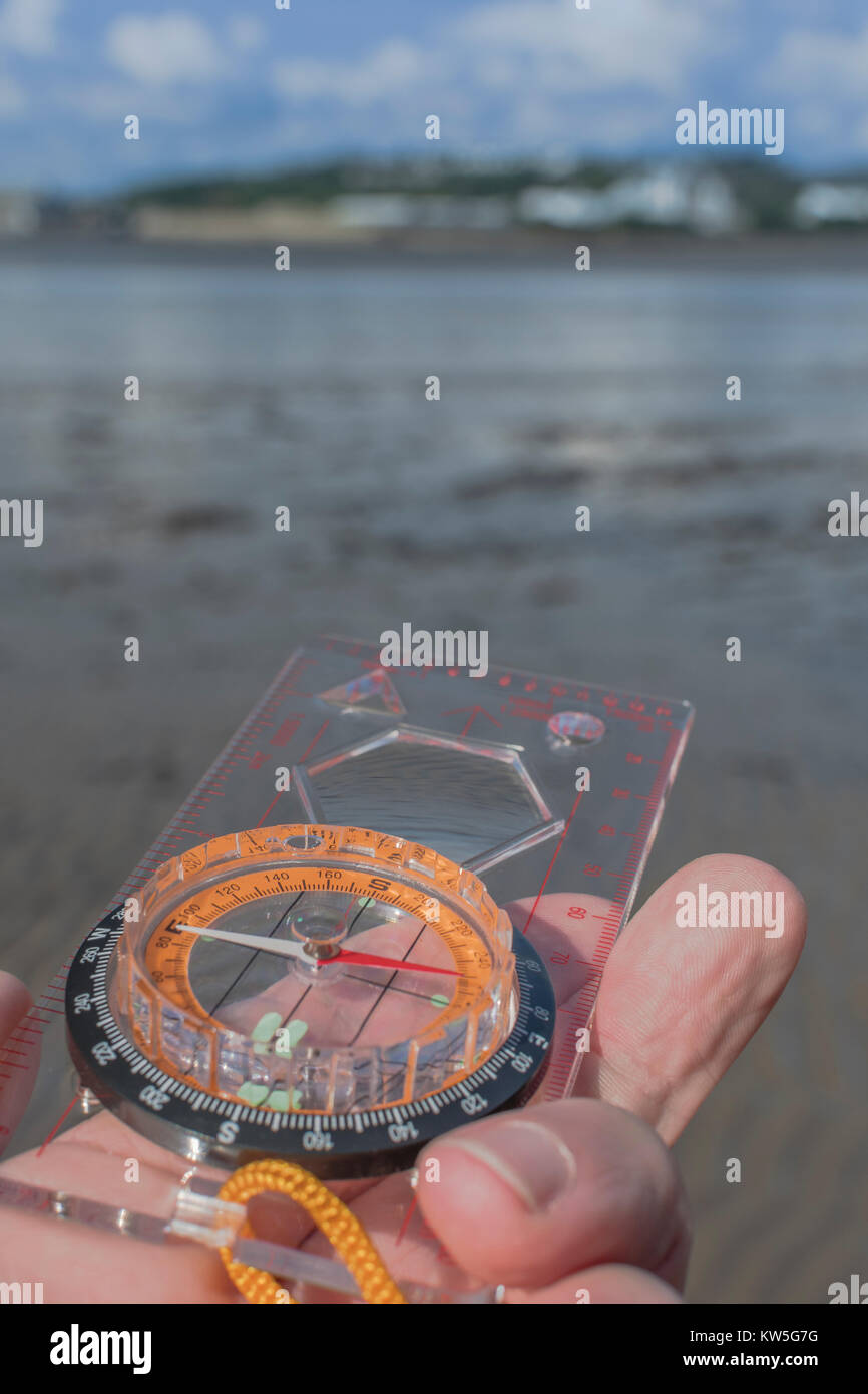 Orienteering compass in hand pointing west. For business 'direction