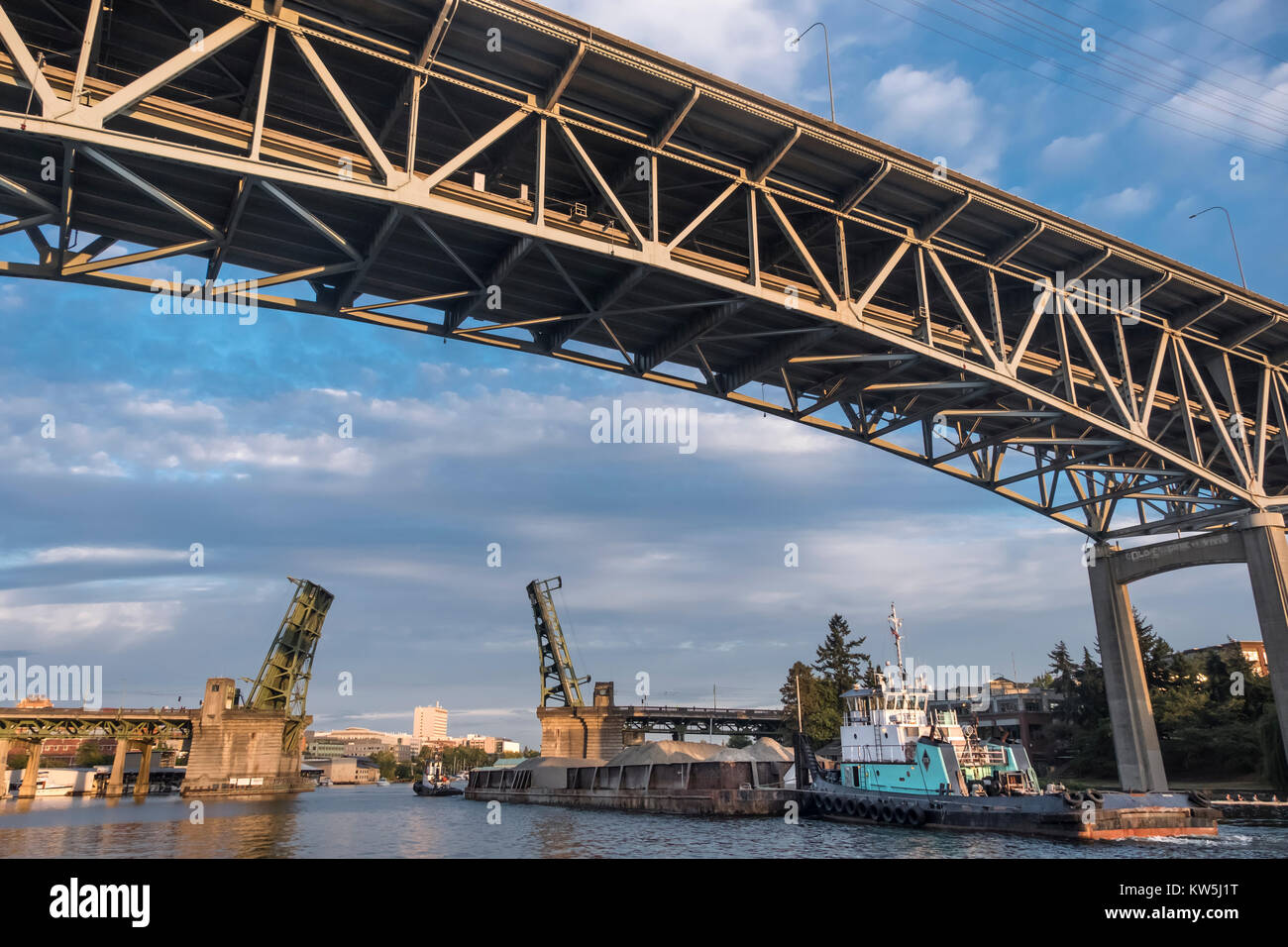 Tugboats taking a barge through to University Bridge and under the I 5 bridge, Seattle, Washington, USA Stock Photo