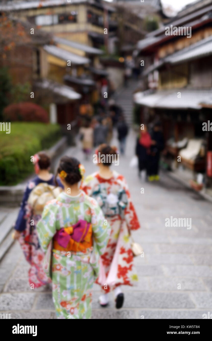 License and prints at MaximImages.com - Three girls in bright kimonos walking down an old street in Kyoto in autumn. Artistic out of focus blurred pho Stock Photo