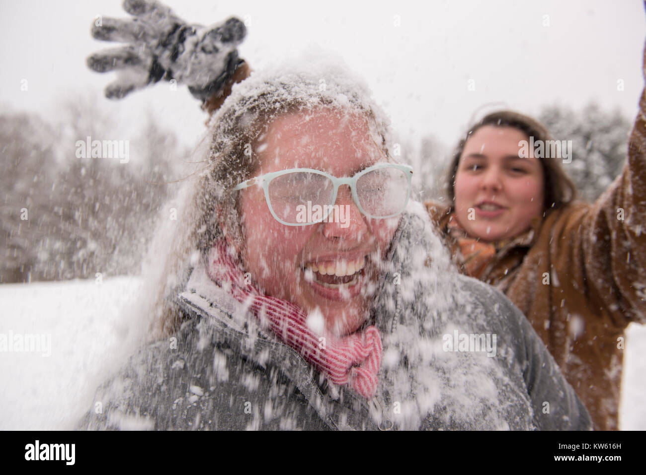 Sisters Eliza, 26, left and Georgia Doolittle, 17 have a snow ball fight in Maine Stock Photo