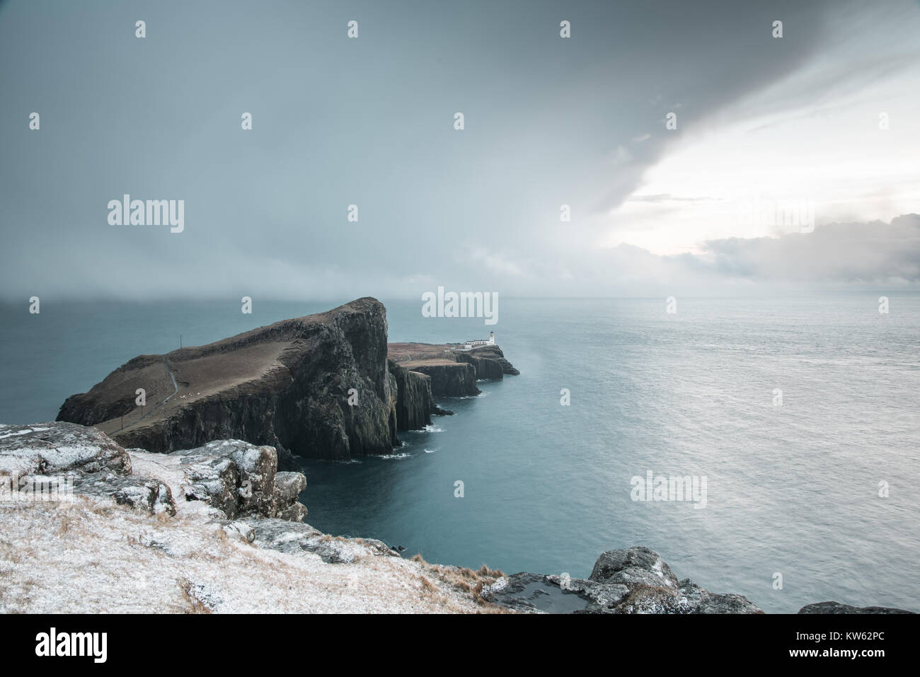 Neist Point Peninsula with White Lighthouse - Isle of Skye Landscape with Stormy Clouds on Sky, Dramatic Cliffs and Spectacular Scottish Scenery Stock Photo