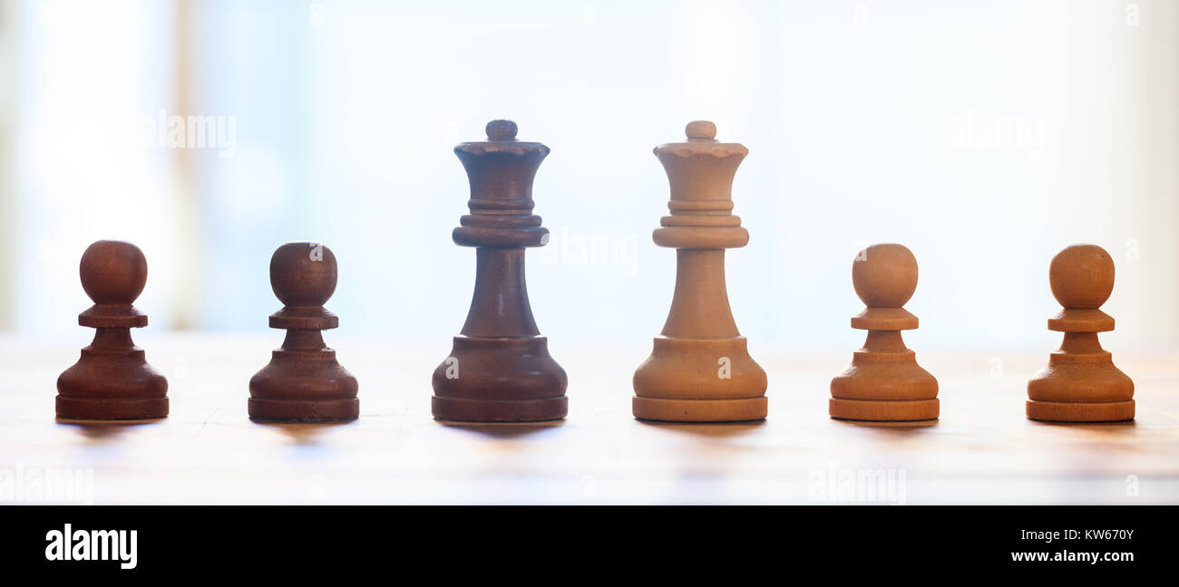 Chess pieces with reflection. Close up view of queens and pawns with details. Blurred backdrop. Stock Photo