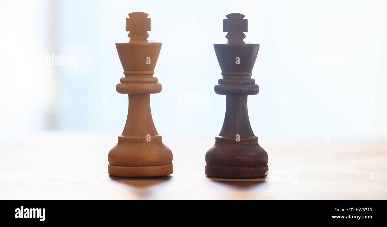 Chess pieces dark, light brown color. Closeup view of kings with detail. Reflection, blur backdrop. Stock Photo