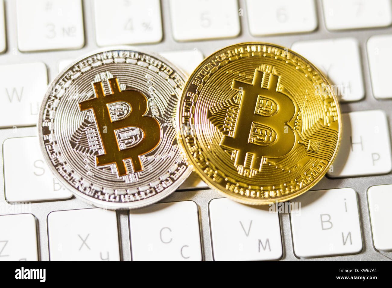 two coins of bitcoin on white laptop keyboard close up Stock Photo - Alamy