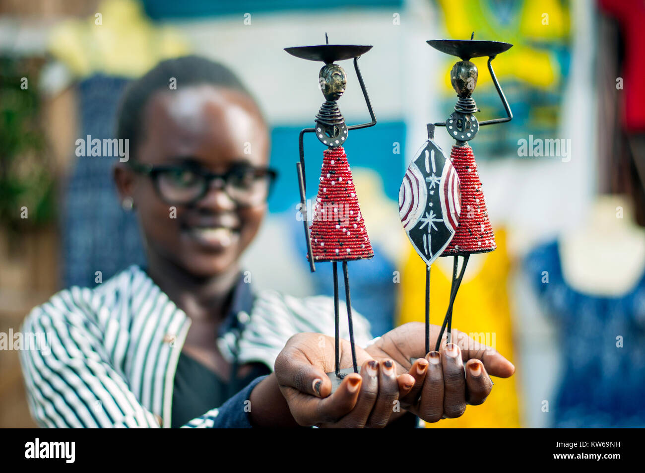 Stall proprietor holding tribal dolls, Craft Centre, Entebbe, Wakiso, Uganda Stock Photo
