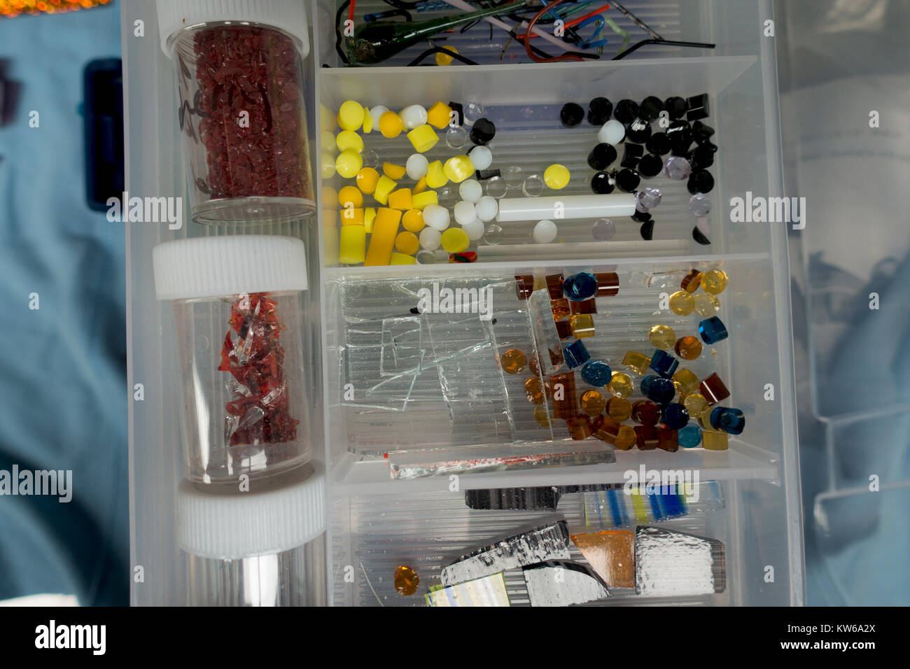 Assorted glass fusing supplies in a craft box. There's frit