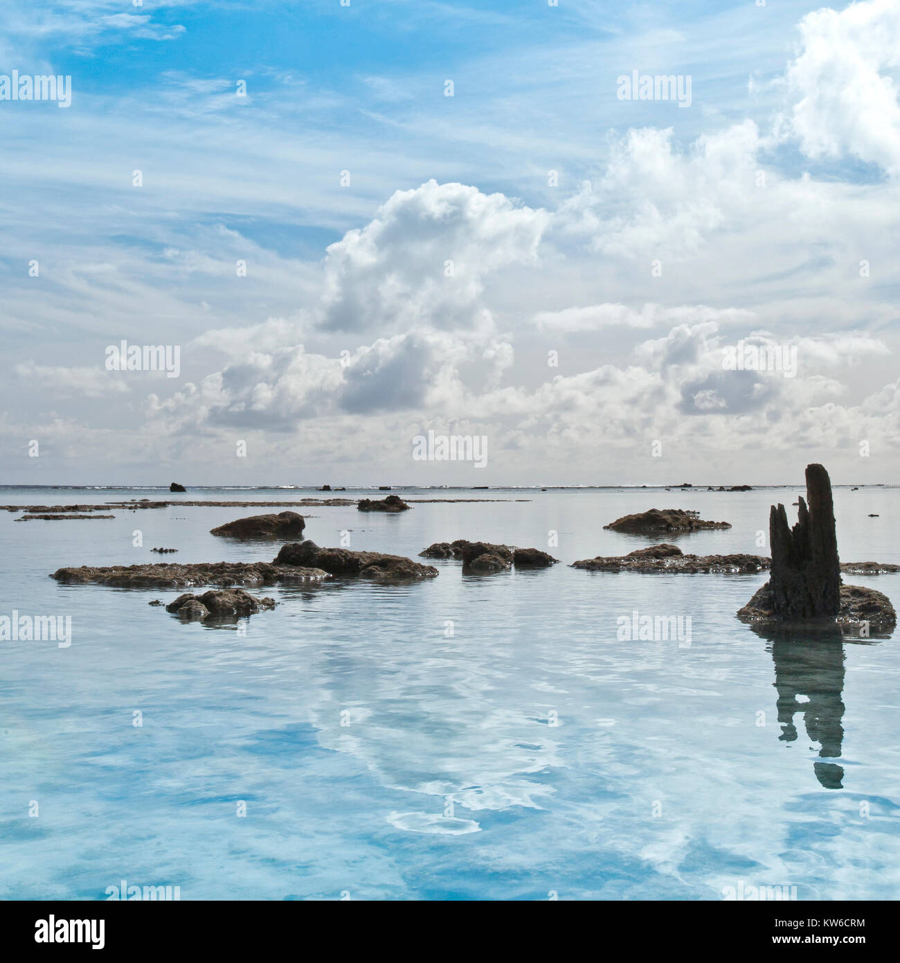 sun sea and sand scapes from the south pacific cook islands Rarotonga and one foot island with dramatic rock formations and reflections Stock Photo