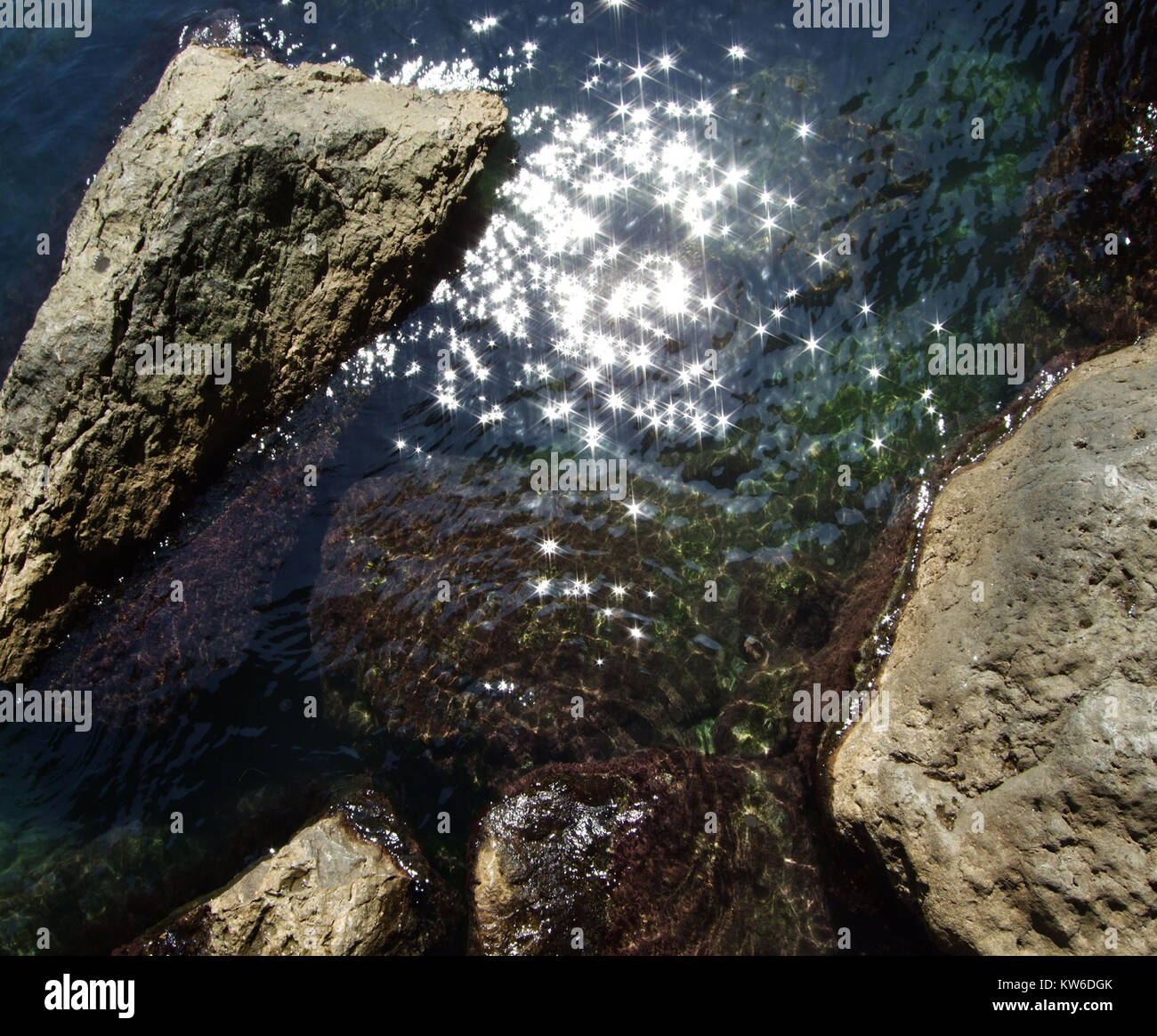 Stones in sea. Water glitters on sun. Stock Photo