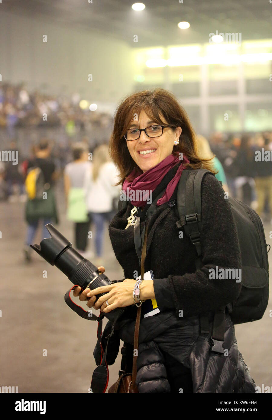 very beautiful female photographer with camera and big lens at live concert Stock Photo