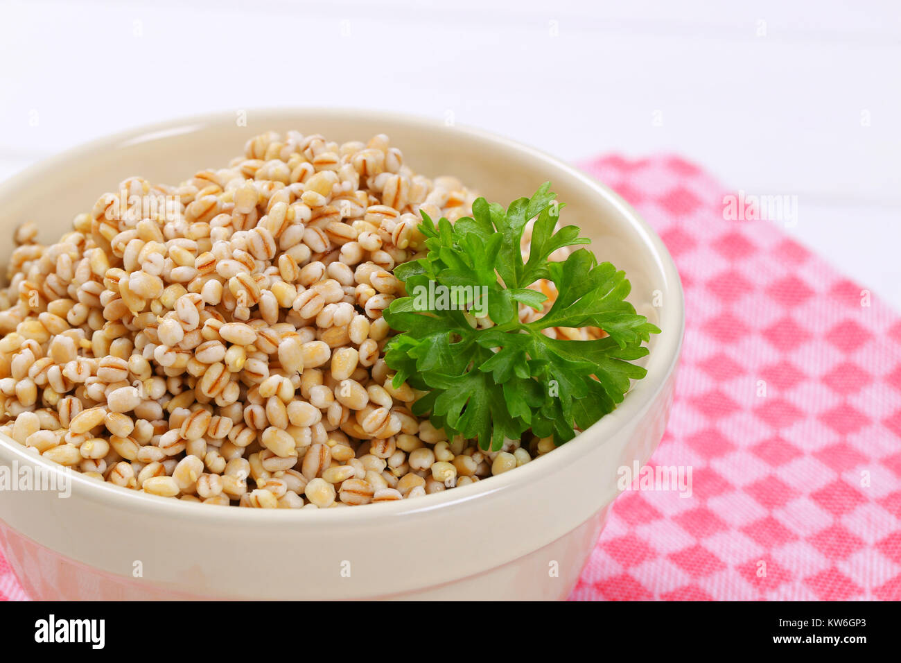 bowl of cooked pearl barley on checkered place mat - close up Stock Photo