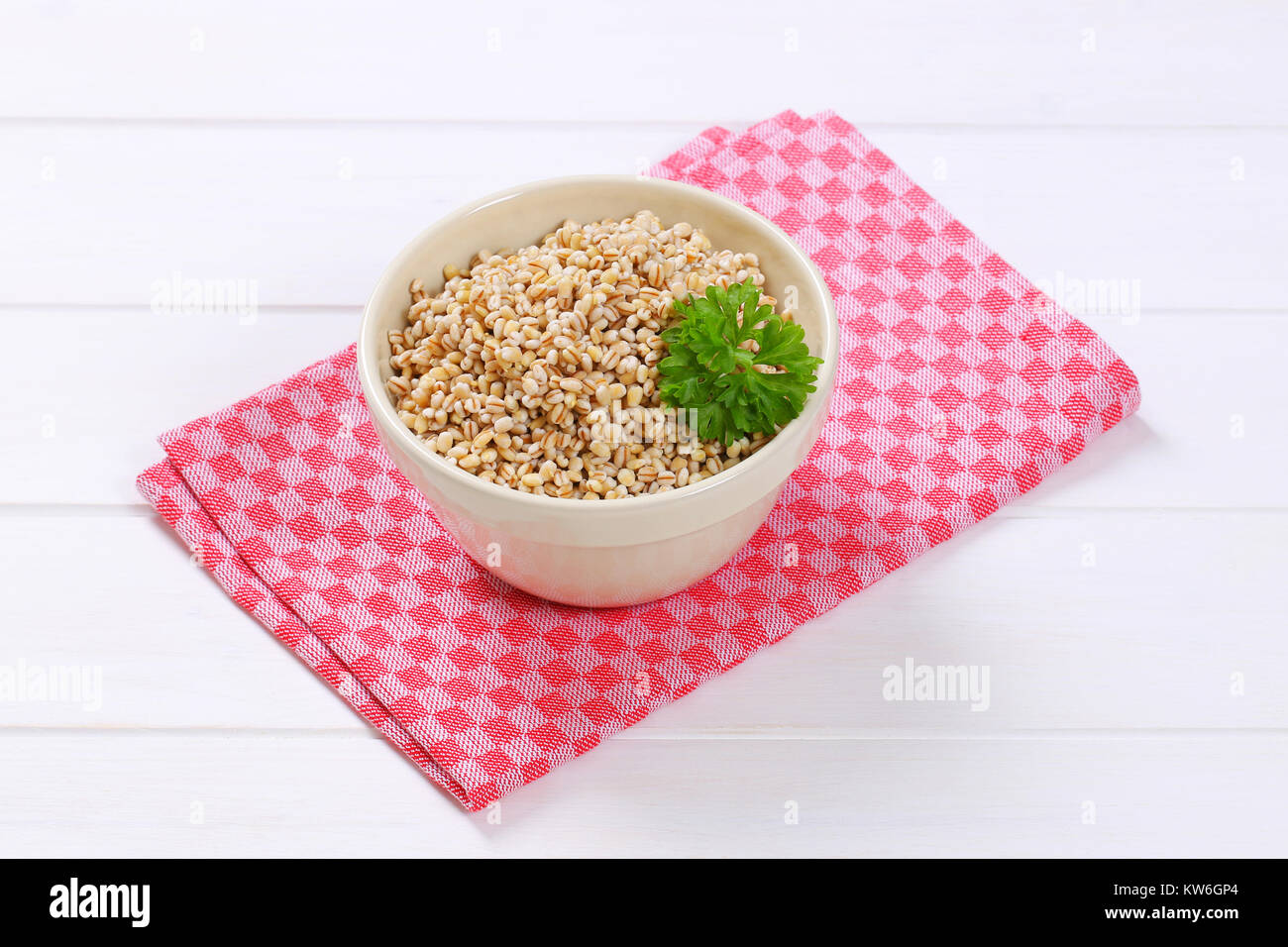 bowl of cooked pearl barley on checkered place mat Stock Photo