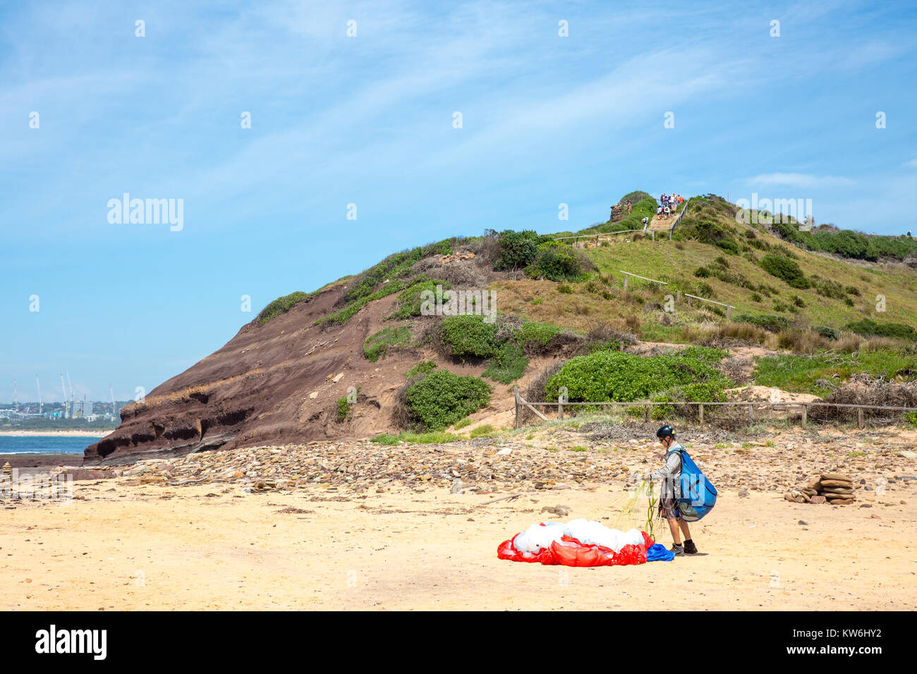 Male paraglider lands at Long Reef Point and collects his canopy together,Sydney,Australia Stock Photo