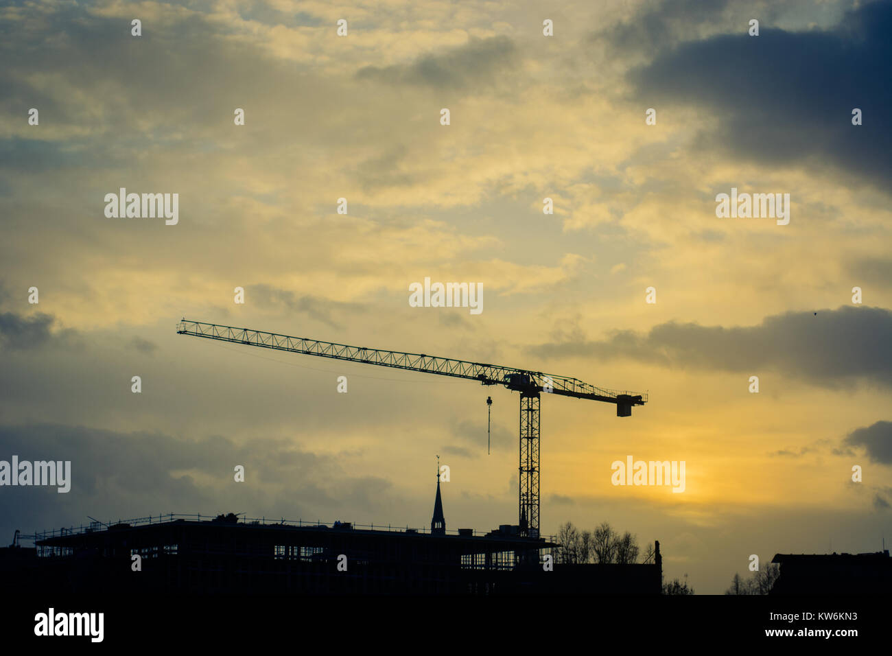 Crane on anonymous city in sundown Stock Photo