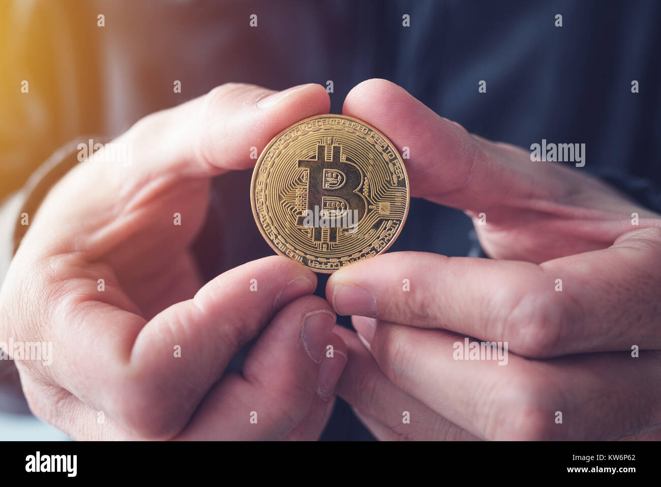 Man showing Bitcoin, close up of hands with BTC cryptocurrency coin Stock Photo