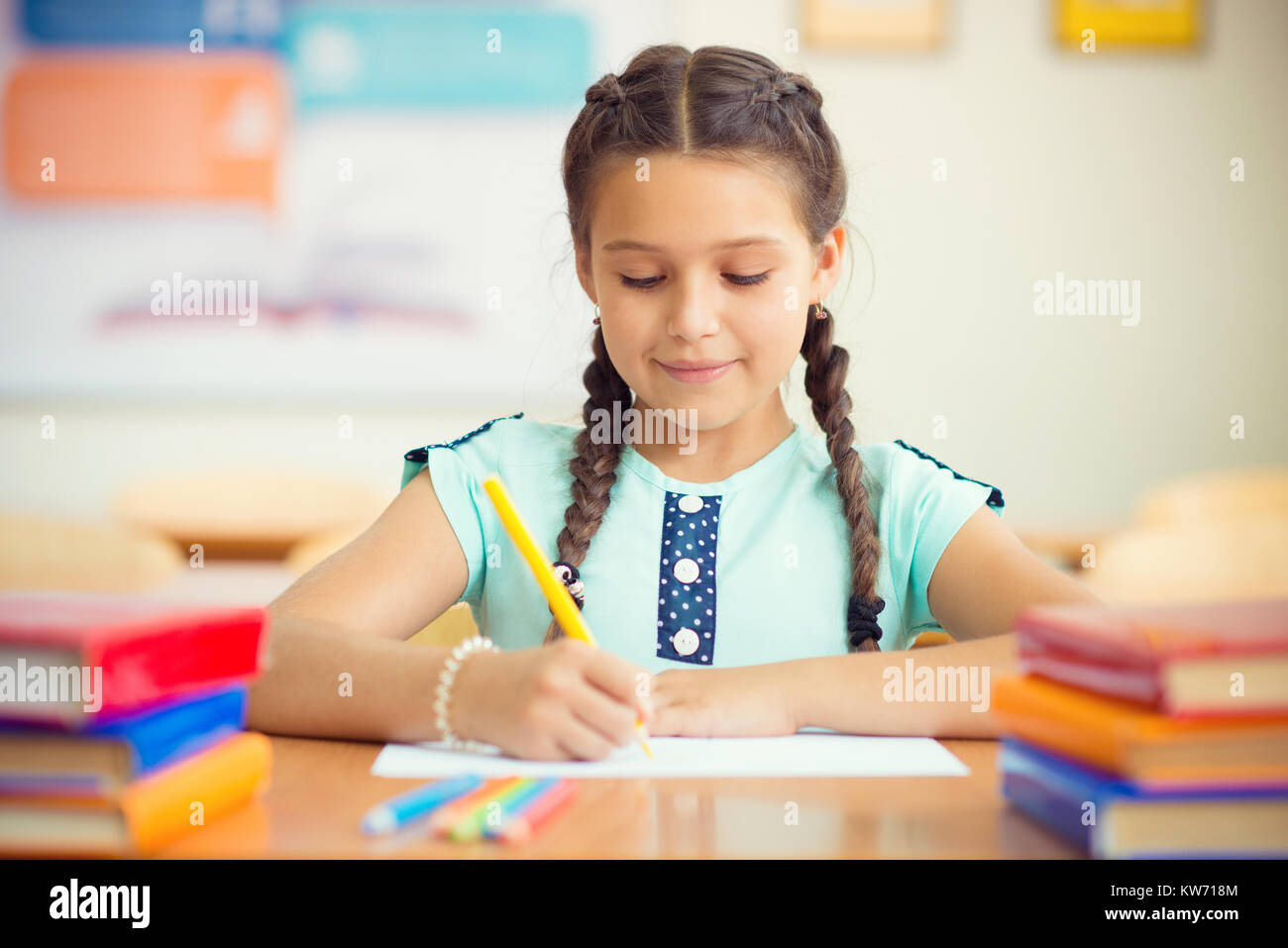 Cute smiling schoolgirl at school during lesson Stock Photo - Alamy