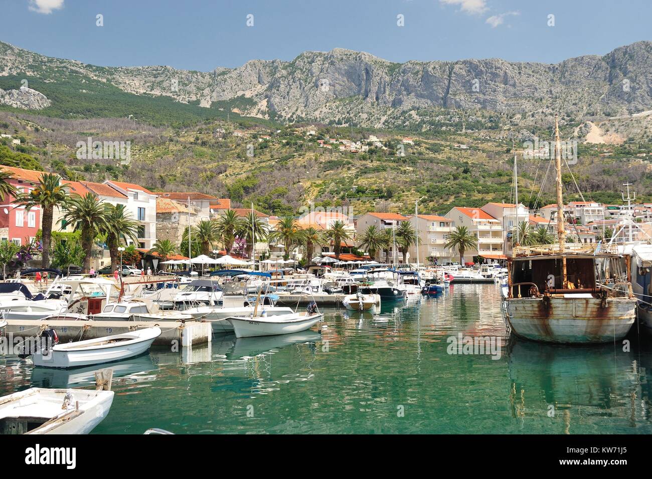 Port of Podgora in Croatia with apartments, boats and with mountain Biokovo in background. Podgora is a popular holiday resort. Stock Photo