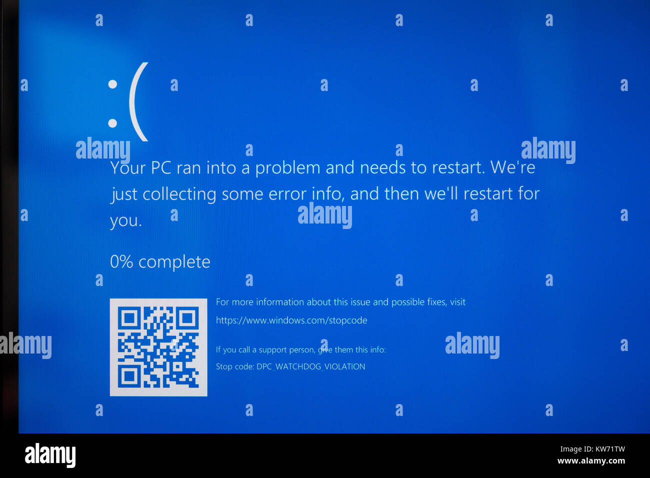 A laptop screen showing 'Your PC ran into a problem and needs to restart.' Theme - computer problems, crash, blue screen, error, broken Stock Photo