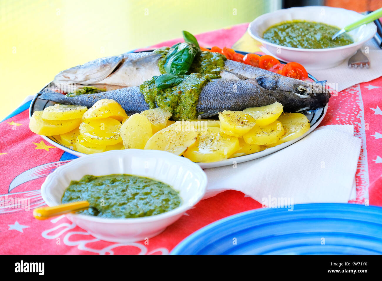european sea bass branzino steaming potatoes tomatoes basil sauce recipe Stock Photo Alamy