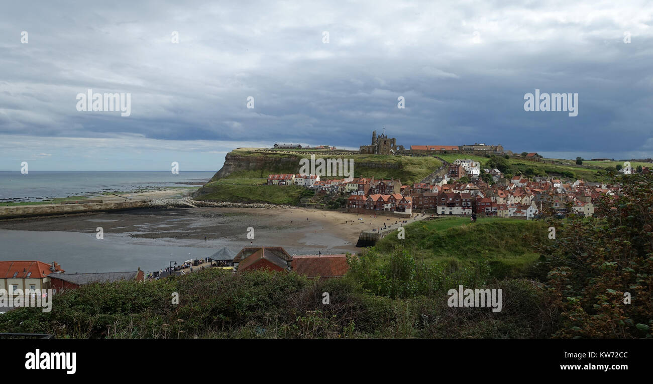 Whitby under a stormy sky. East Cliff, church and Abbey from West Cliff. Mouth of River Esk. Stock Photo