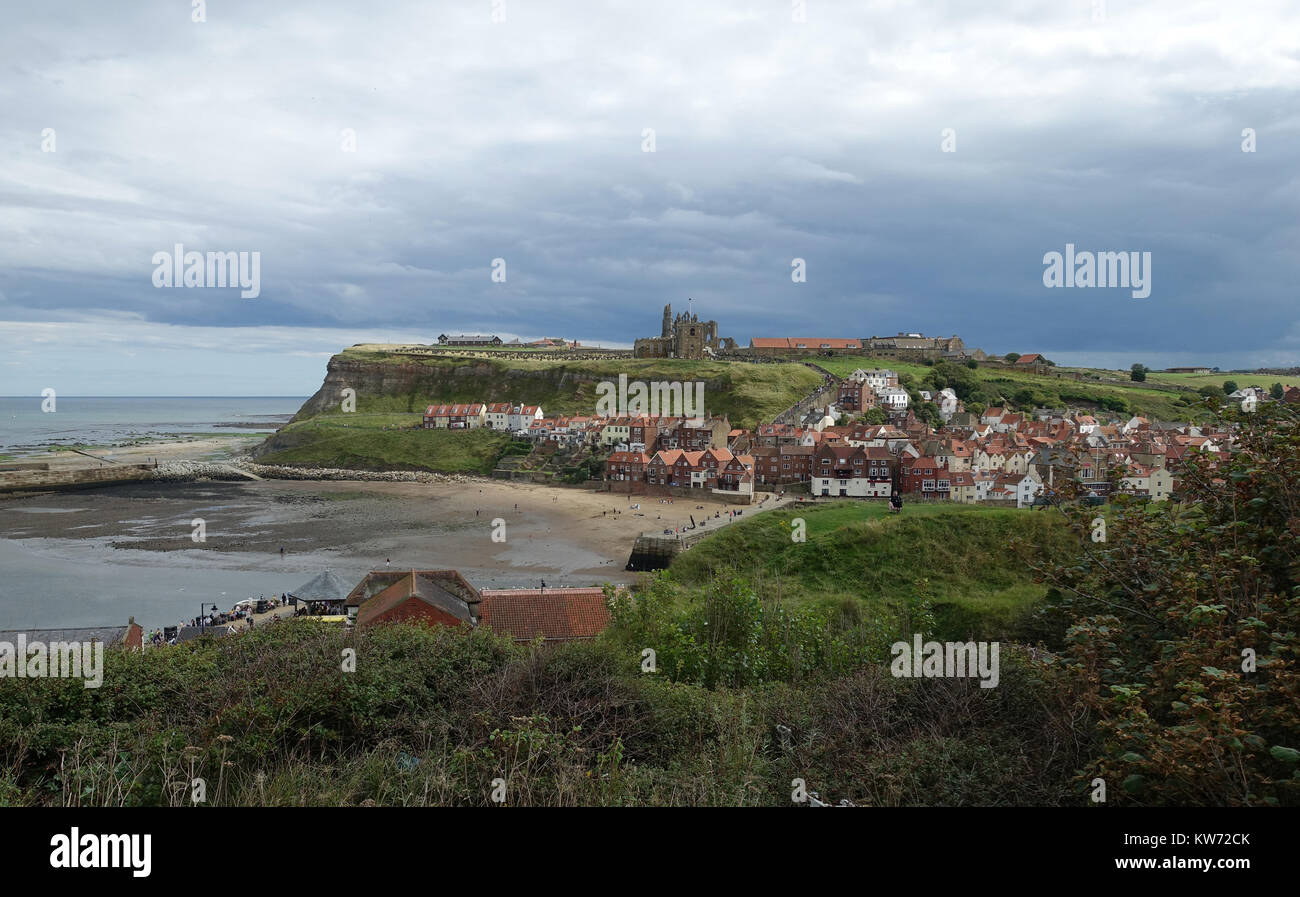 Whitby and the mouth of the Esk under a stormy sky.  East Cliff, church and Abbey from West Cliff.  Yorkshire. Stock Photo