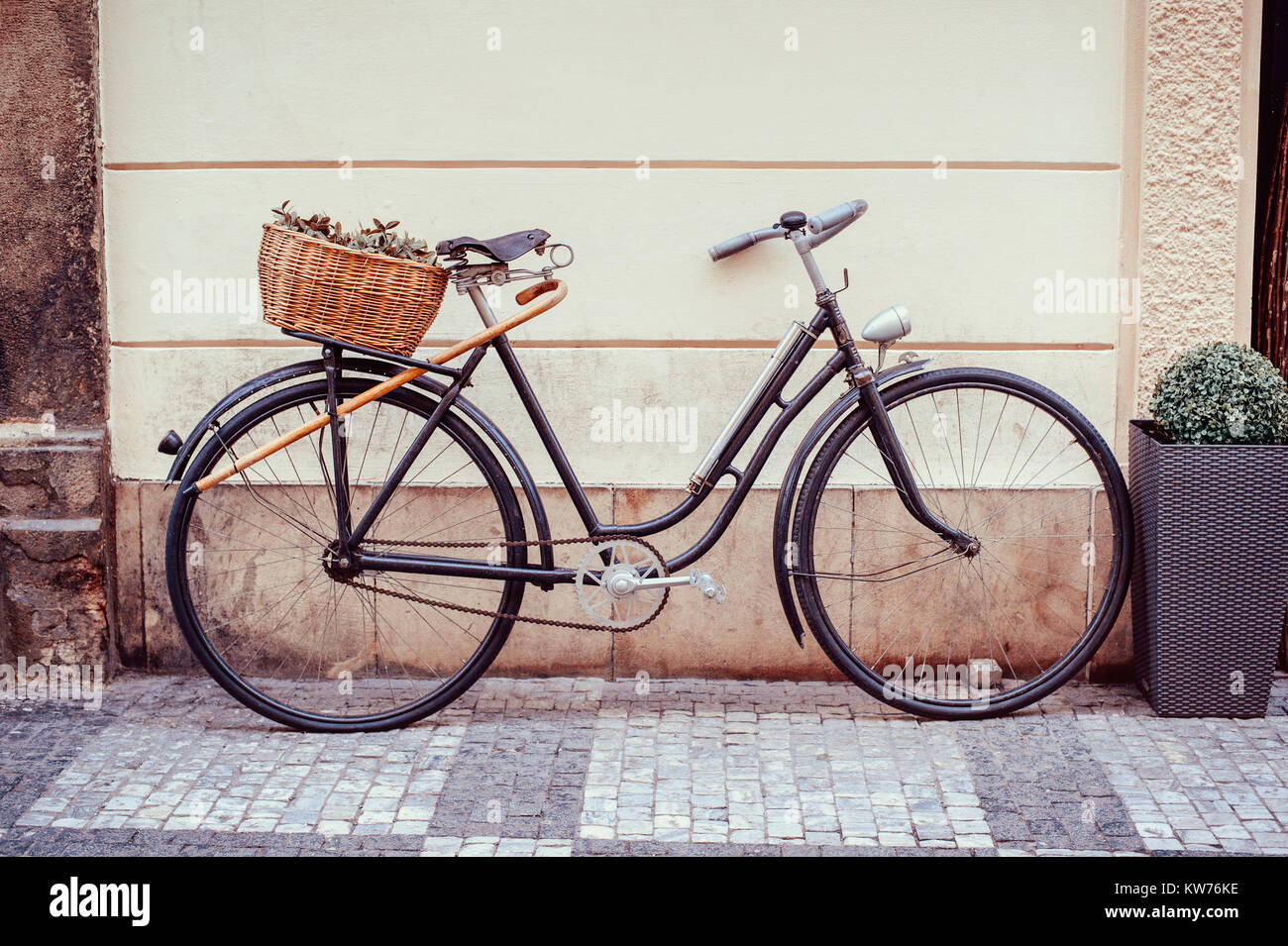 Vintage bicycle with an old basket at the back of it left in the street of Prague s old town Stock Photo Alamy