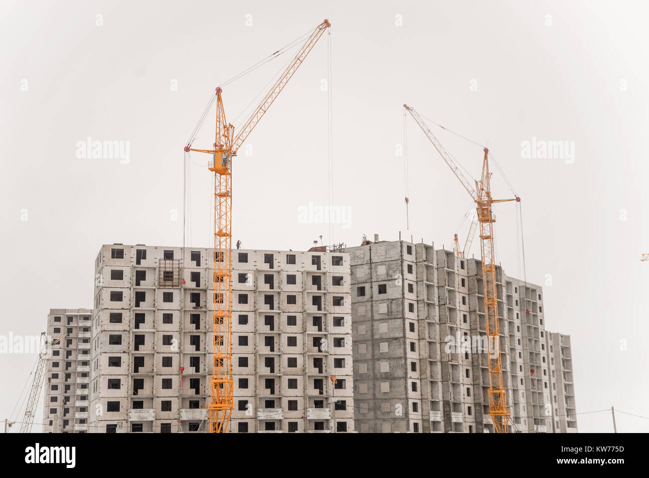 Building crane and building under construction against blue sky Stock Photo