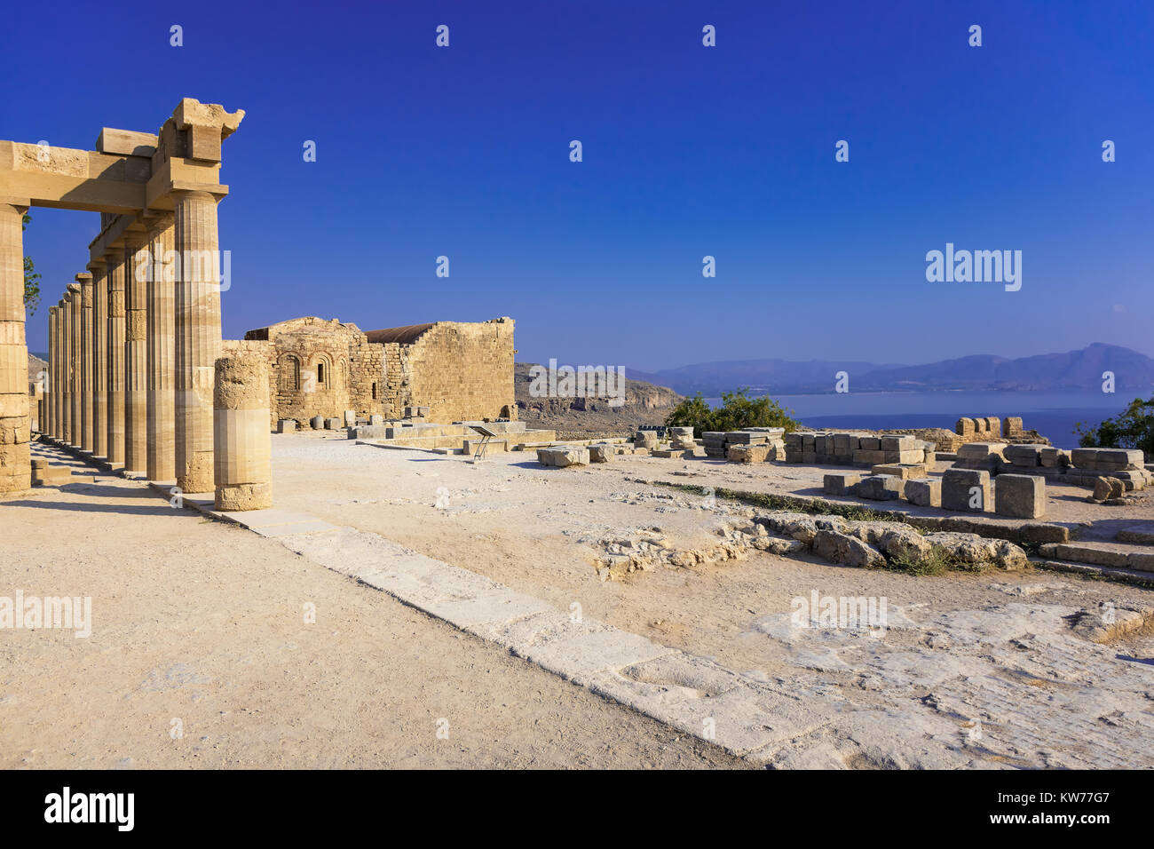 Columns of Portico and Church of St. John on the Acropolis of Lindos (Rhodes, Greece) Stock Photo