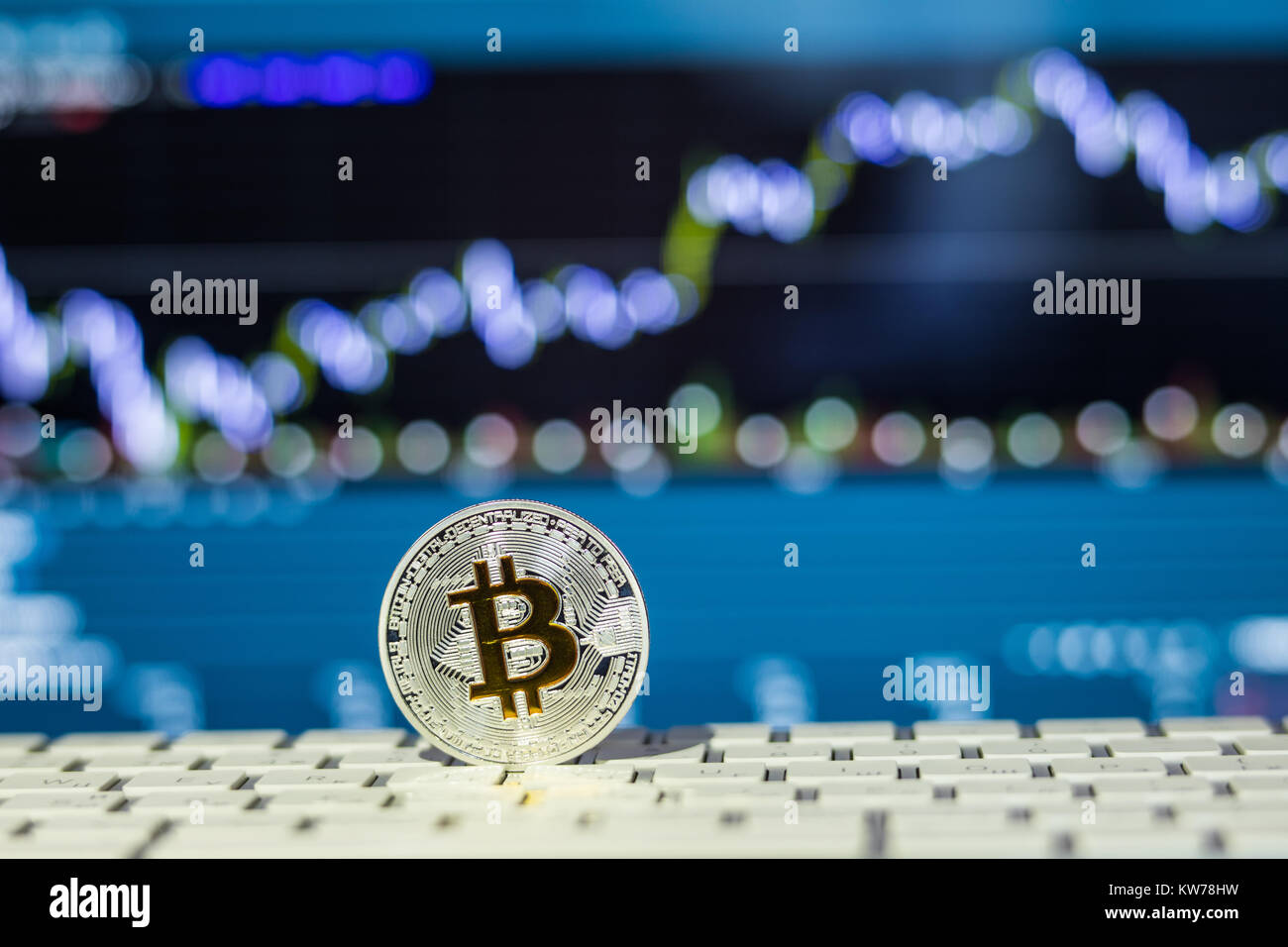 Bitcoin coin on a keyboard with blurred background, symbol for raising ...