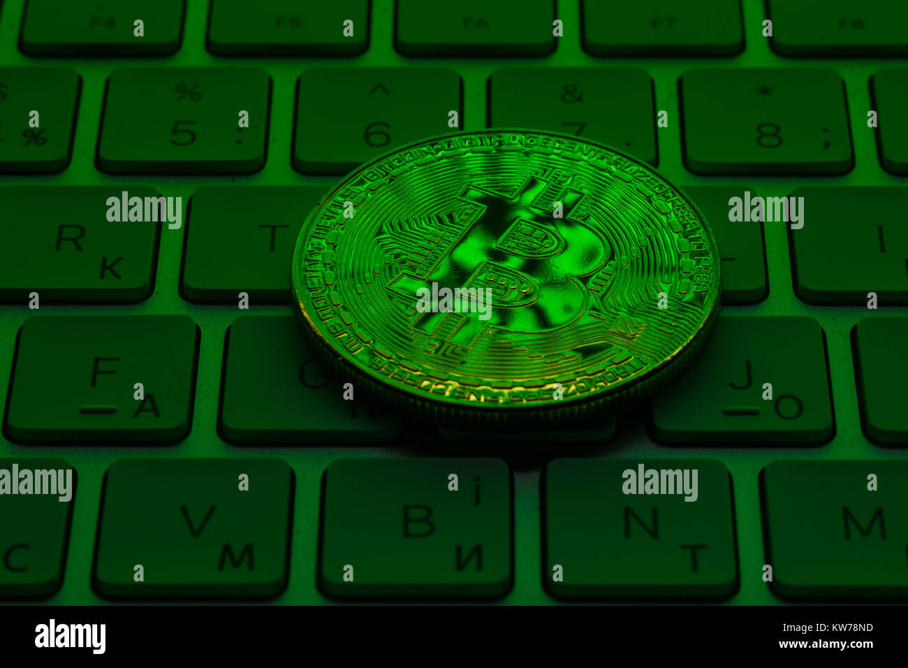 Gold Plated Iron Bitcoin on laptop keyboard with green neon light Stock  Photo - Alamy