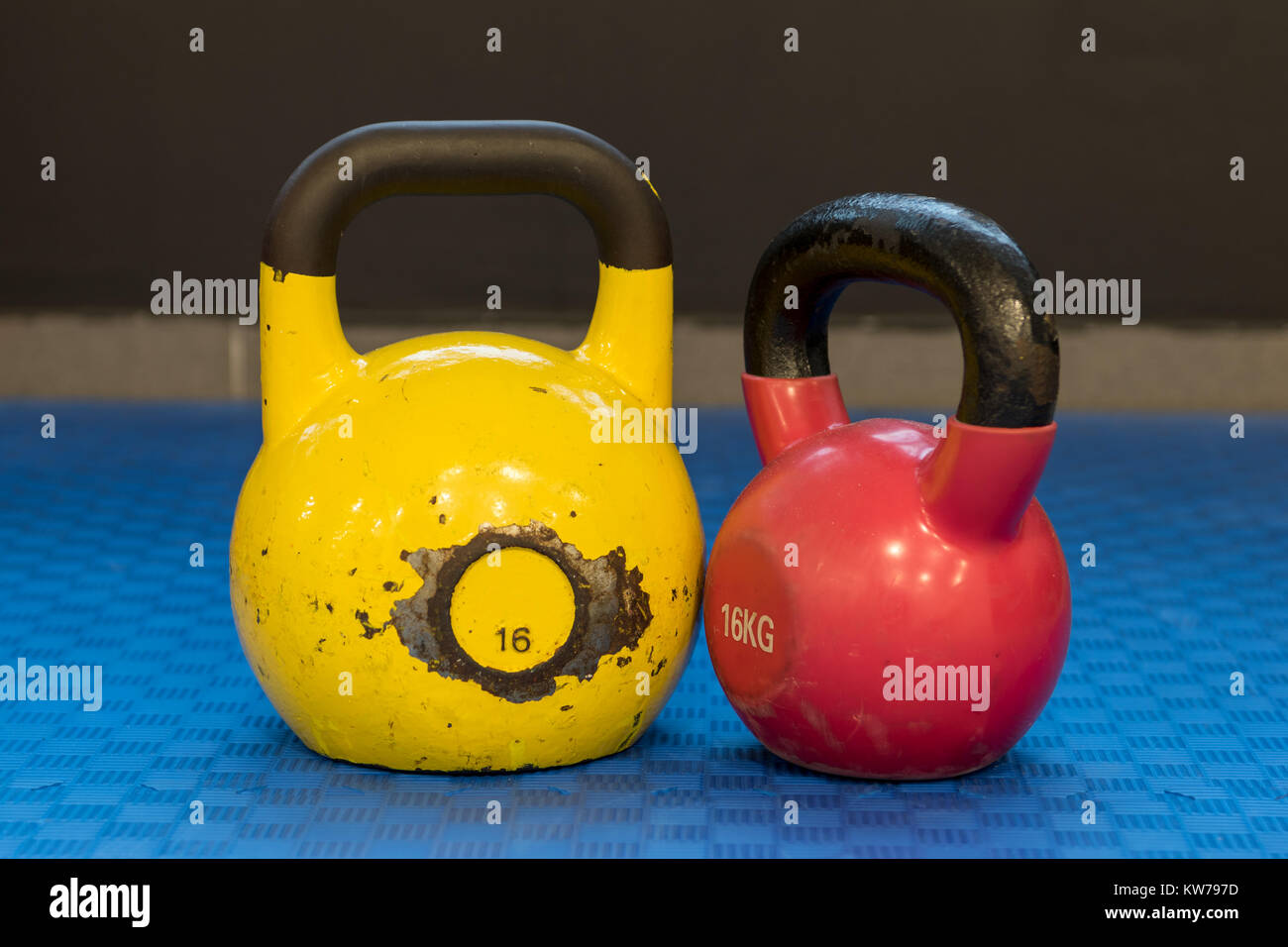 Red and yellow used and old kettlebells on a blue background. Workout