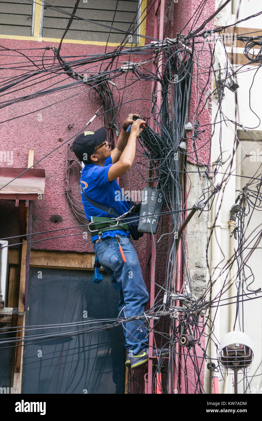 An electrician working on a mass of overhead cables,Cebu City