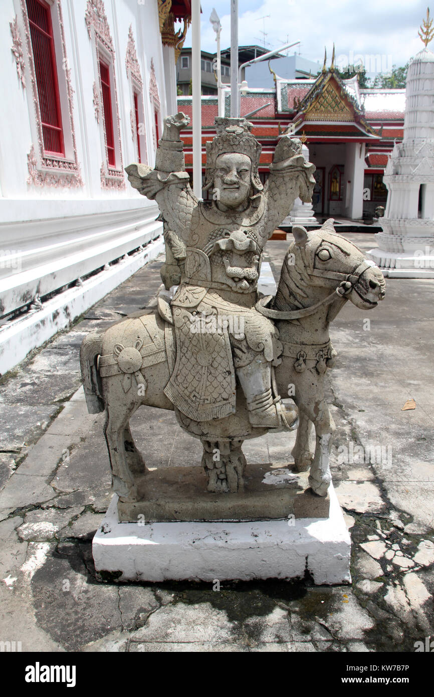 Cement sculpture of wise man near wall of temple in wat Stock Photo