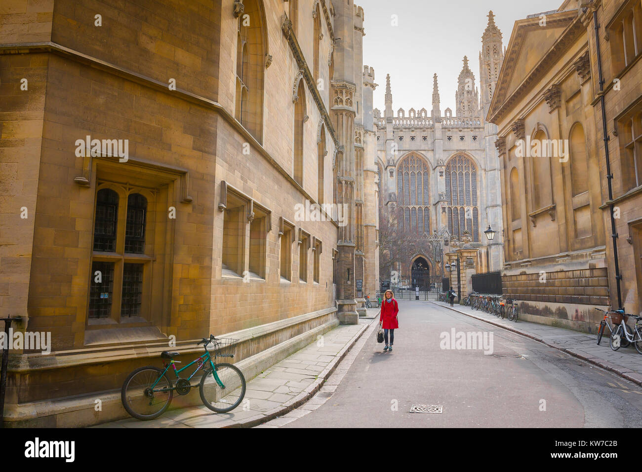 Cambridge student UK, view of a female university student wearing a red coat walking along Trinity Lane in the centre of Cambridge, England, UK Stock Photo