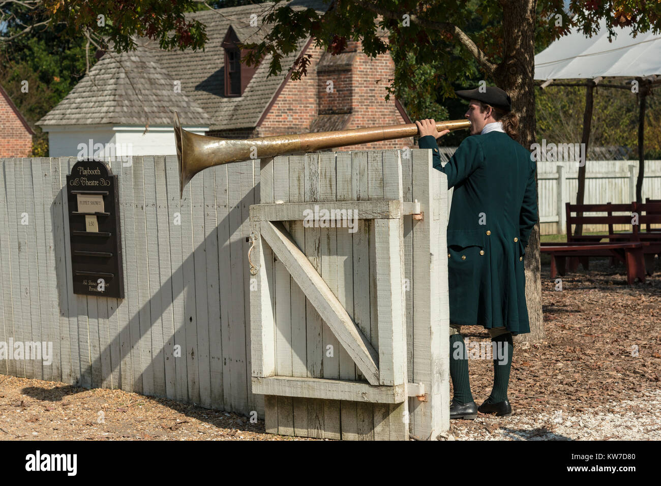Costumed interpreter sounds a horn calling people to a performance at the Play Booth Theater. Stock Photo