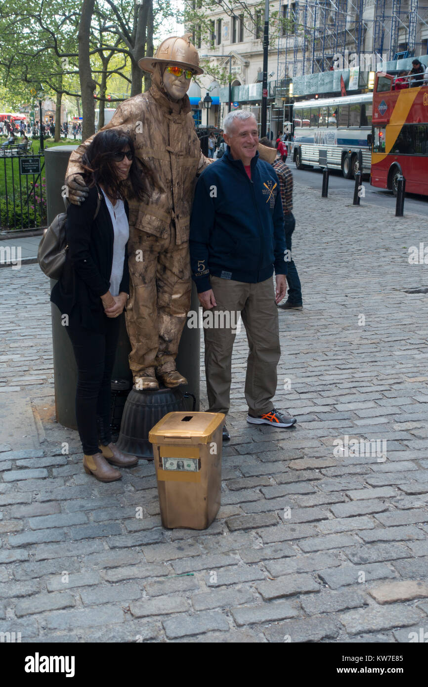 tourists taking photo with fireman statue in NYC Stock Photo