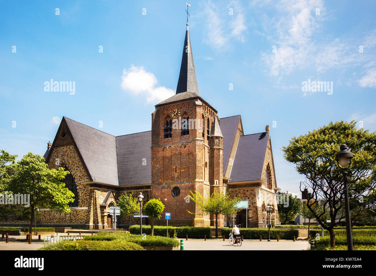 Catholic Church Sint-Martinuskerk in Houthalen-Helchteren, Belgium. Man on a bicycle. Stock Photo