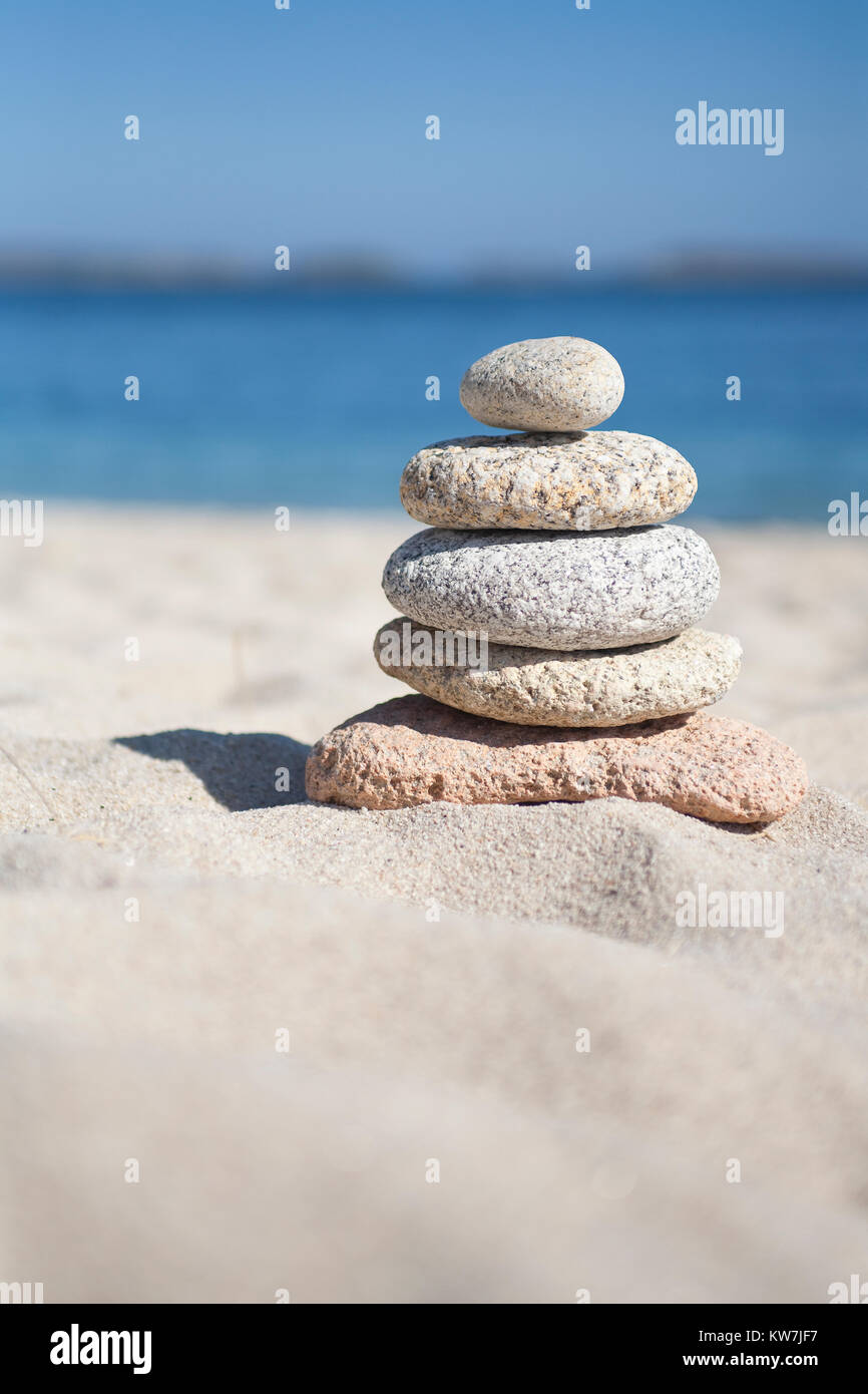 Stones stacked on one another on a sandy beach Stock Photo