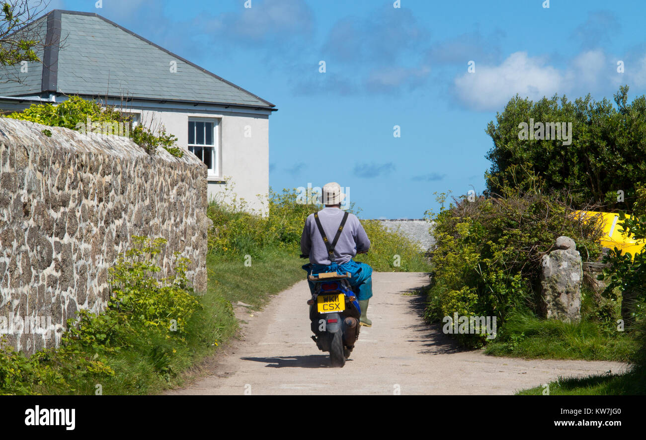 Man rides a Scooter down an english Country Lane Stock Photo