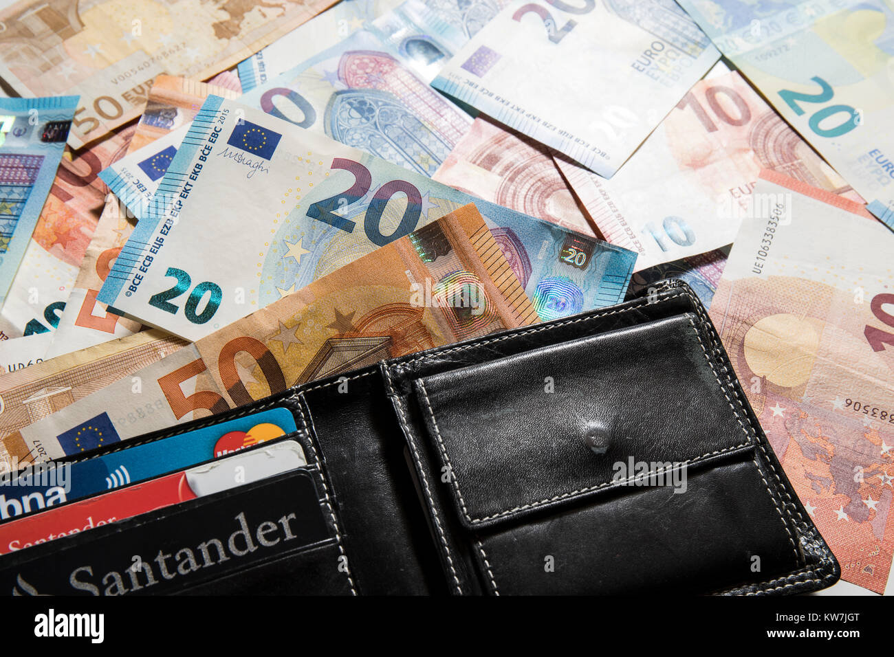 10, 20 & 50 value Euro notes, randomly arranged with a black wallet. Stock Photo