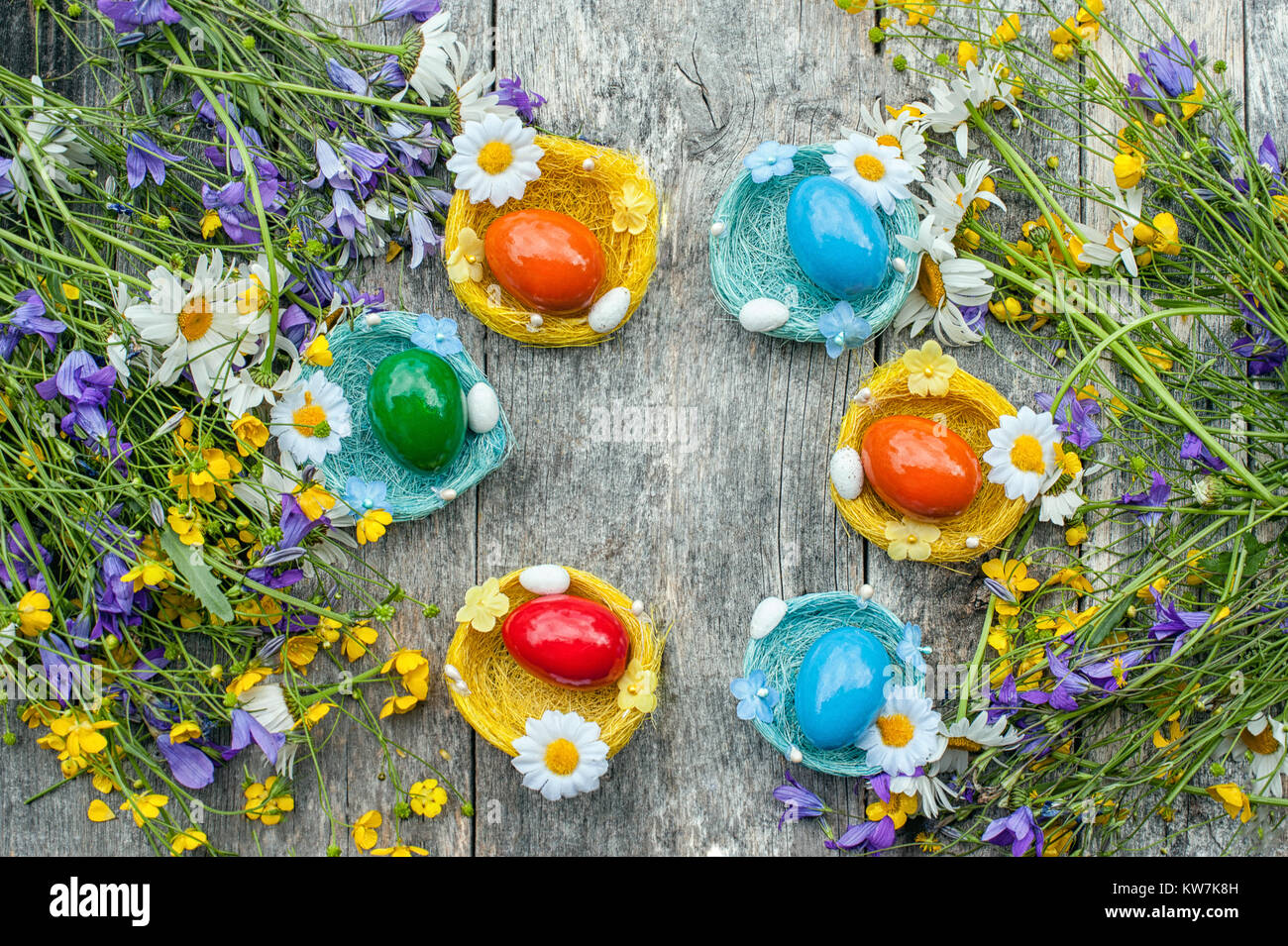 Colorful Easter eggs lying on the wicker plates in the form of a nest ...