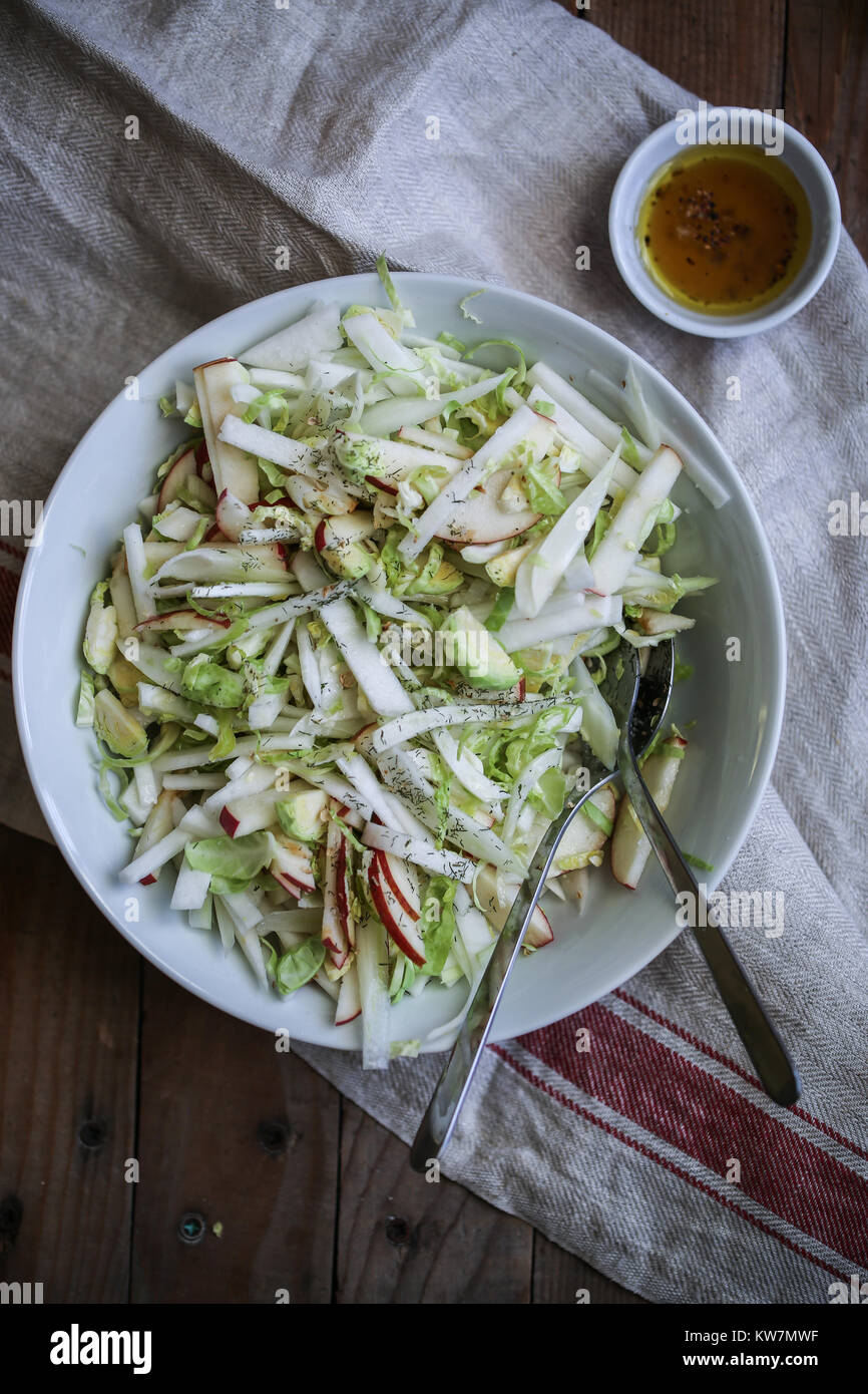 Fresh healthy vegan salad with fennel, brussels sprout, apples, celery, white turnip. With spicy citronette and chilli flakes. Stock Photo
