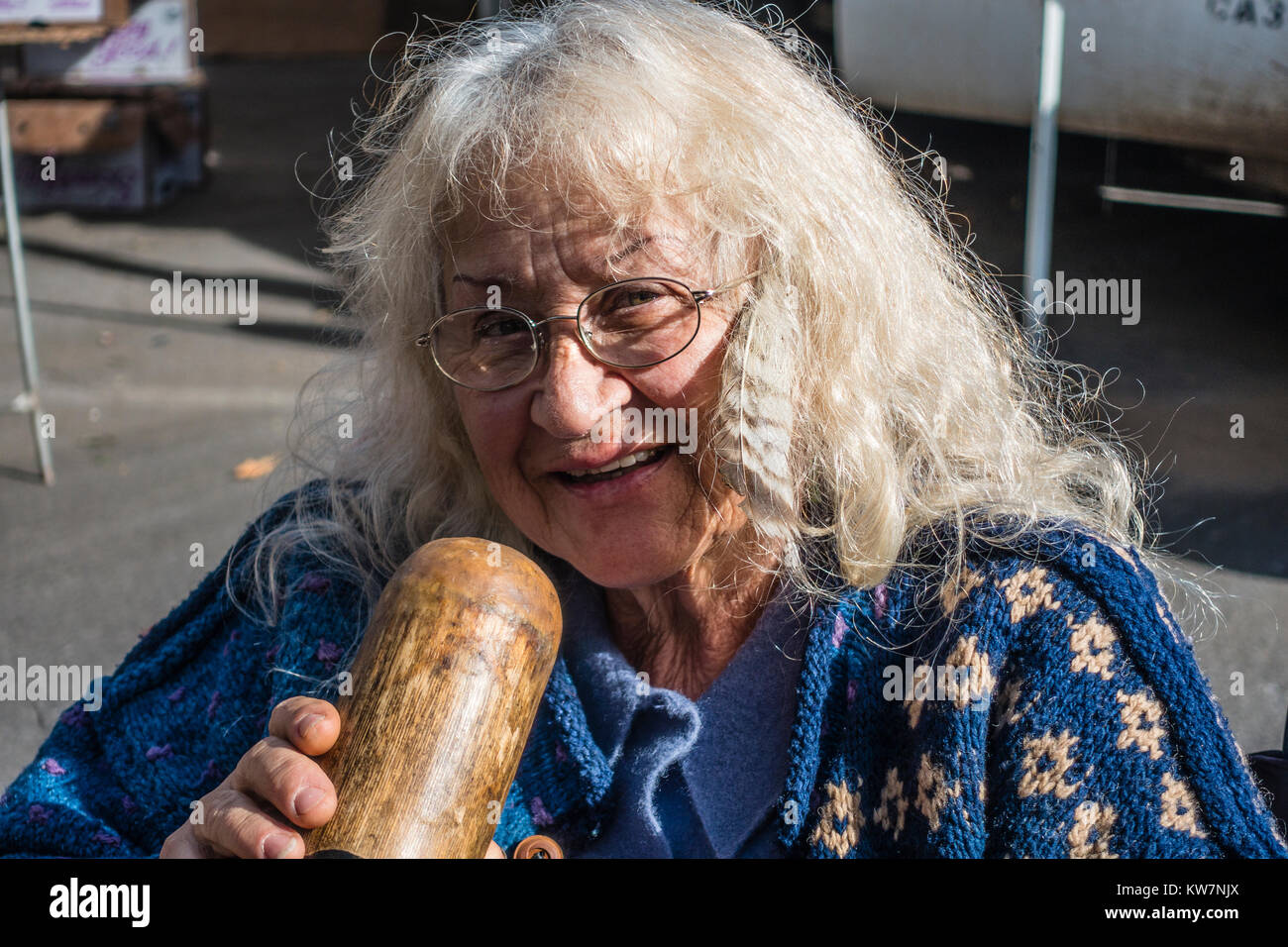 Woman playing didgeridoo at the Santa Barbara, California farmer's market. The didgeridoo (also known as a didjeridu) is a wind instrument. Stock Photo